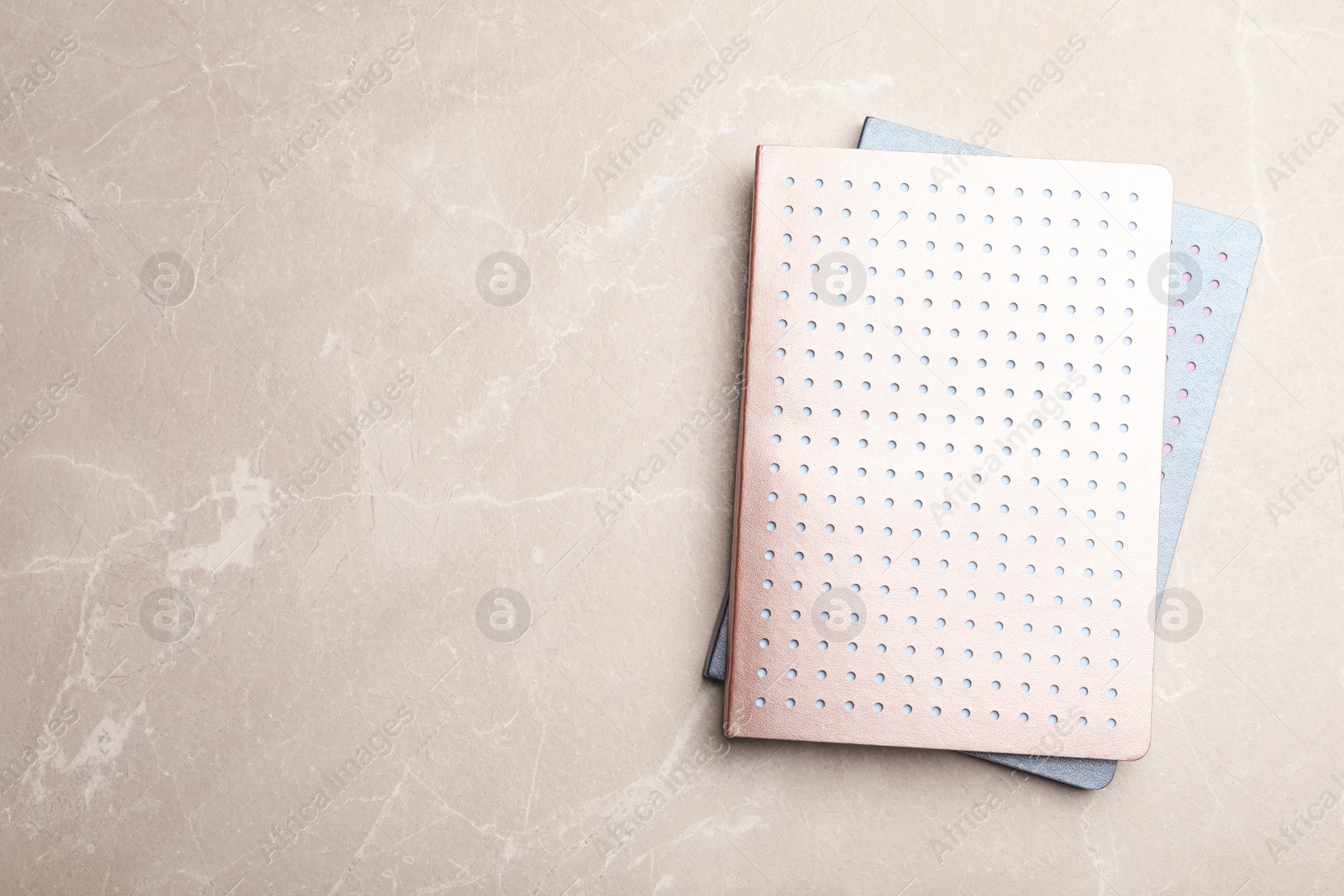 Photo of Stylish notebooks on marble table, top view. Space for text