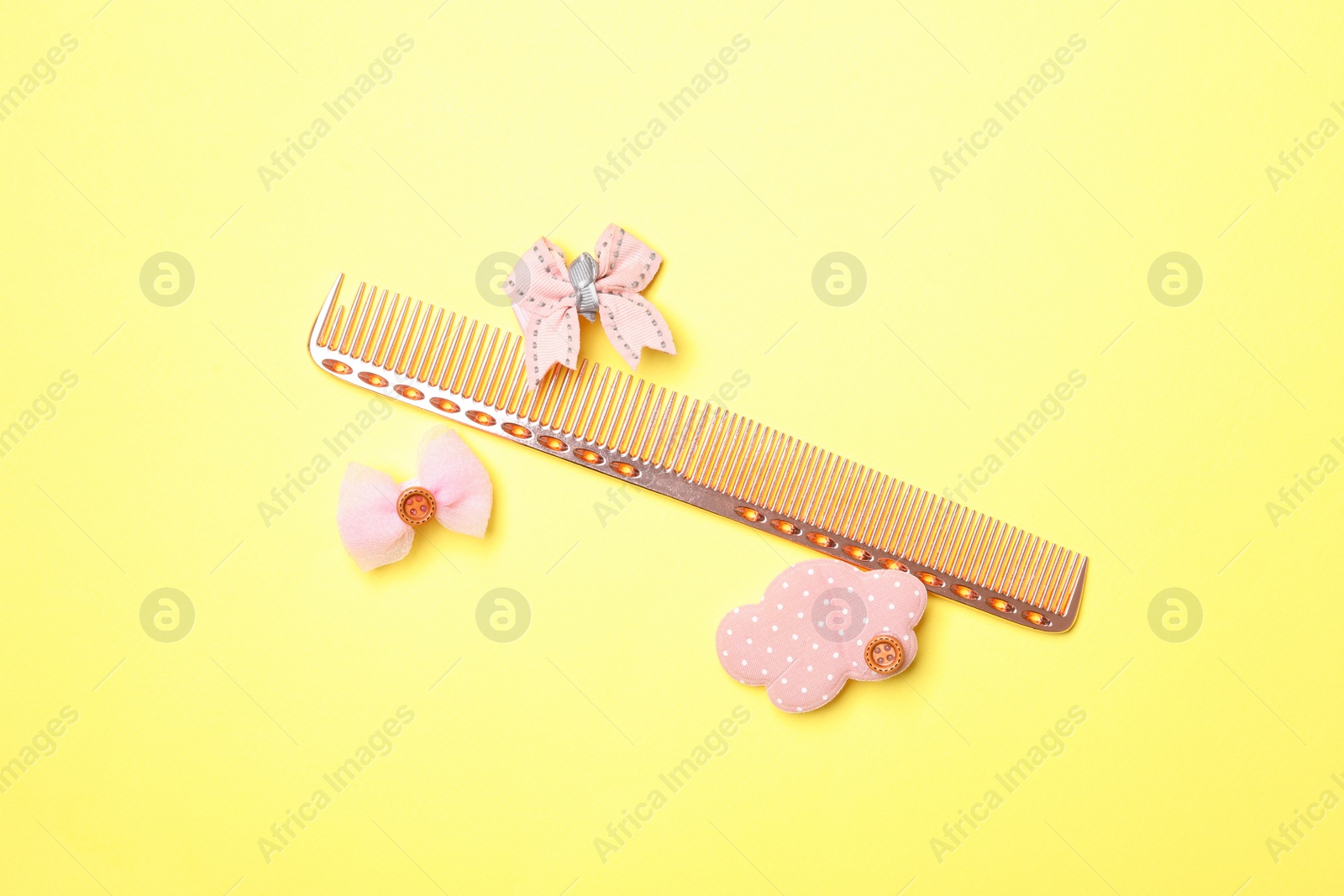 Photo of Flat lay composition with modern hair comb on yellow background