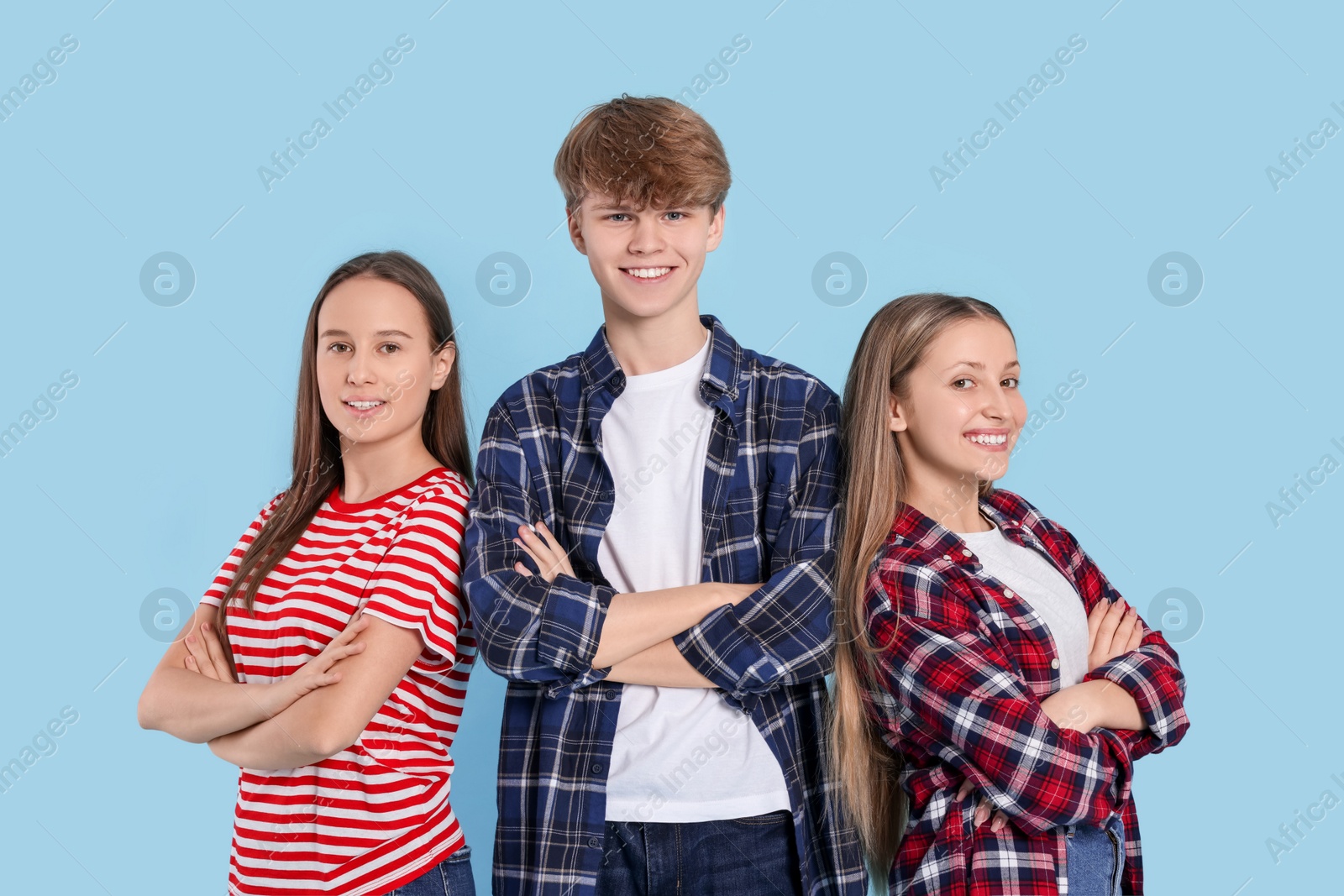 Photo of Group of happy teenagers on light blue background