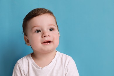 Photo of Cute little baby boy on light blue background, space for text