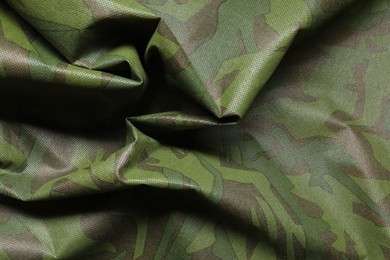 Photo of Texture of crumpled camouflage fabric as background, top view