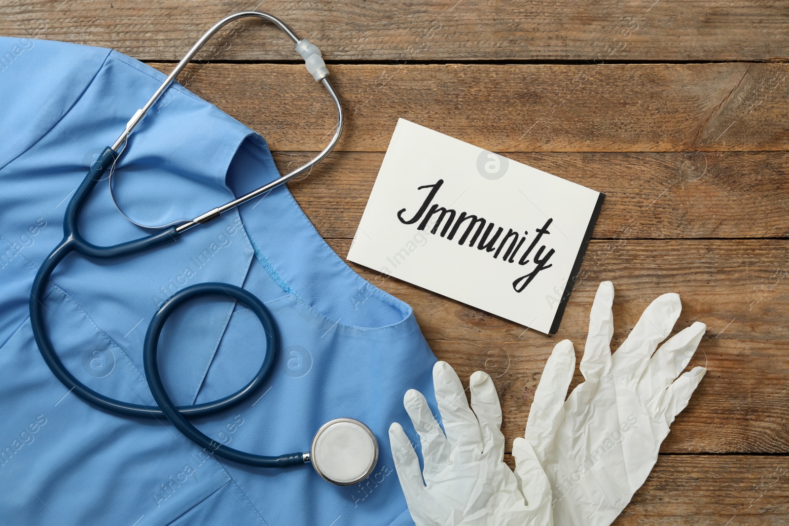 Photo of Paper card with word Immunity and medical items on wooden table, flat lay