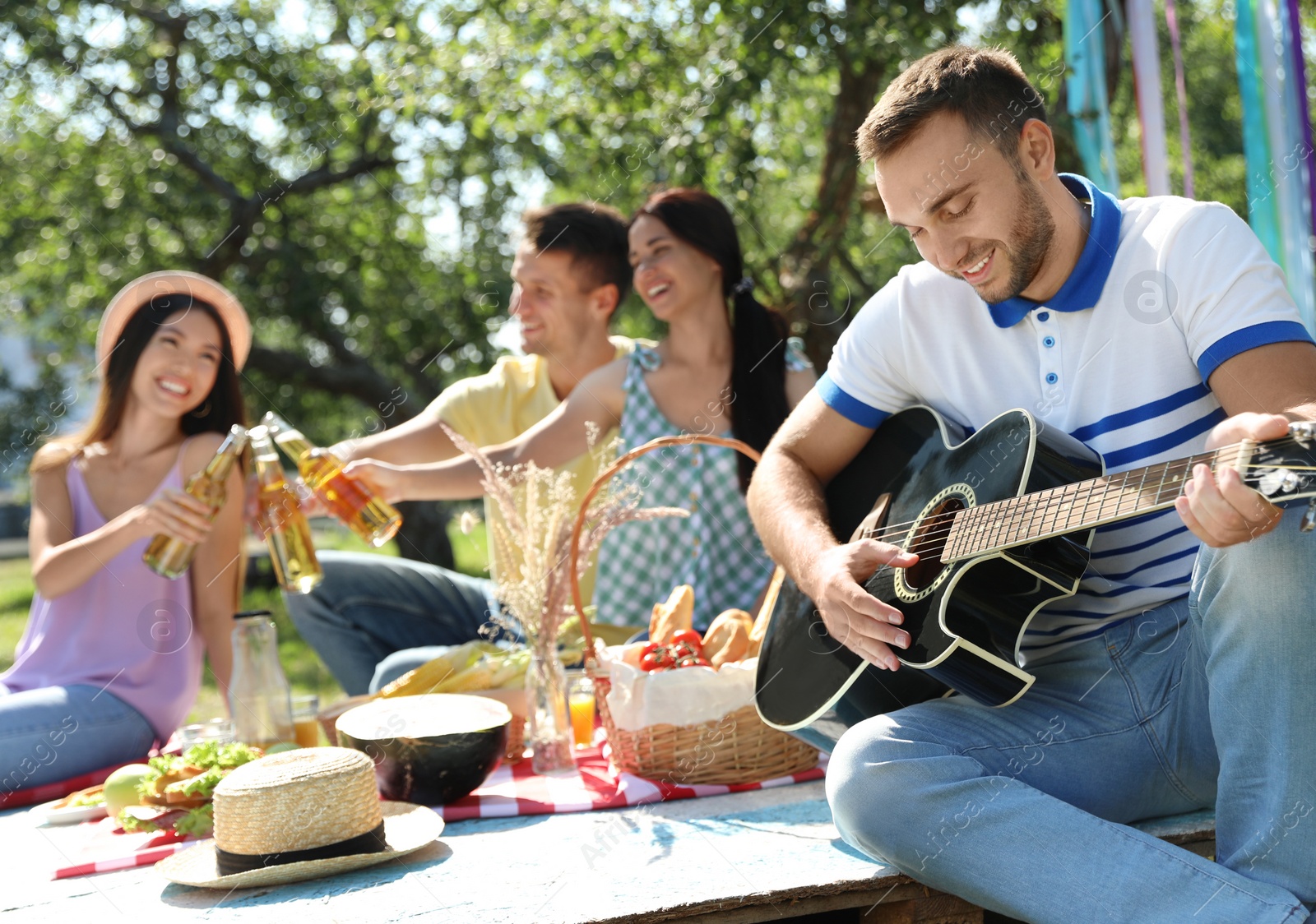 Photo of Young people enjoying picnic in park on summer day