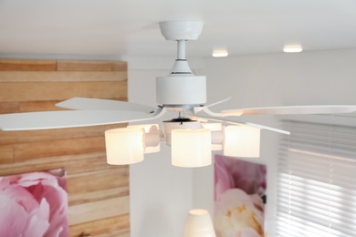 Photo of Modern ceiling fan with lamps indoors. Interior element