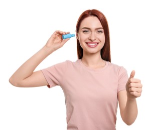 Woman using ear drops on white background