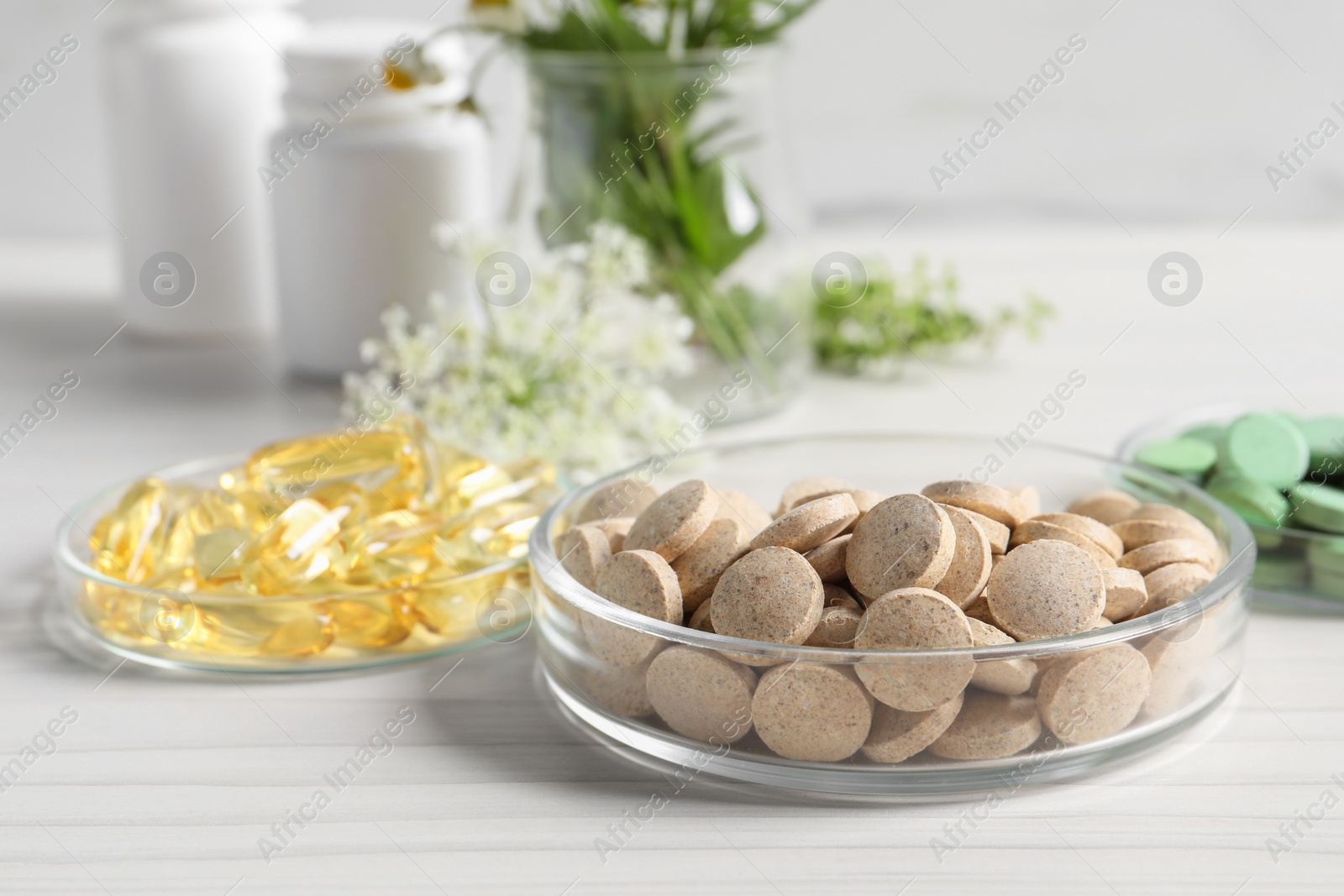 Photo of Different pills on white wooden table, closeup. Dietary supplements