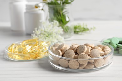 Photo of Different pills on white wooden table, closeup. Dietary supplements