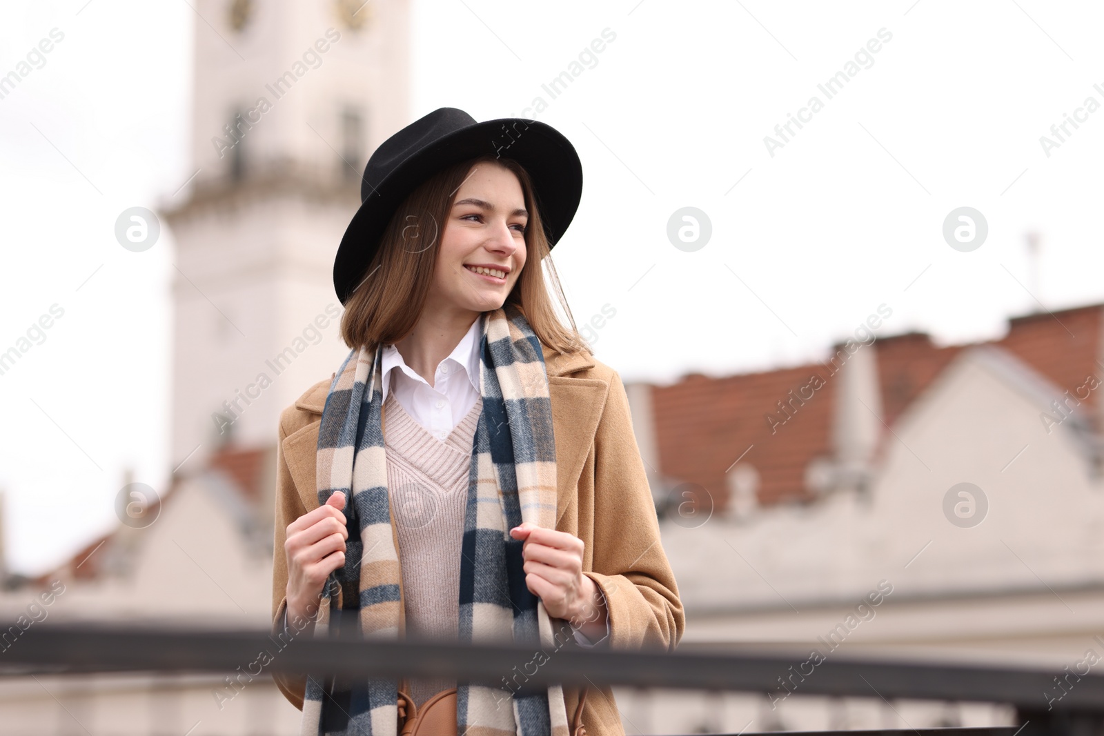 Photo of Beautiful woman in warm scarf and hat outdoors, space for text