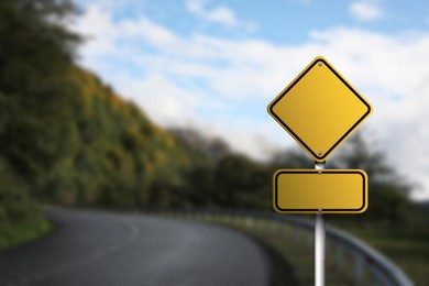 Blank yellow road sign on empty asphalt highway, space for text