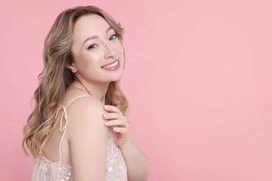 Photo of Portrait of smiling woman on pink background. Space for text