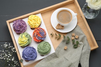 Photo of Different colorful cupcakes and coffee on grey table, top view