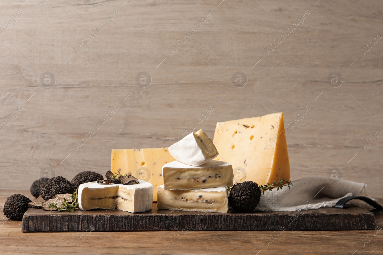 Photo of Different types of cheese and fresh truffles on wooden table