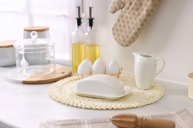 Photo of Set of different utensils and eggs on countertop in kitchen