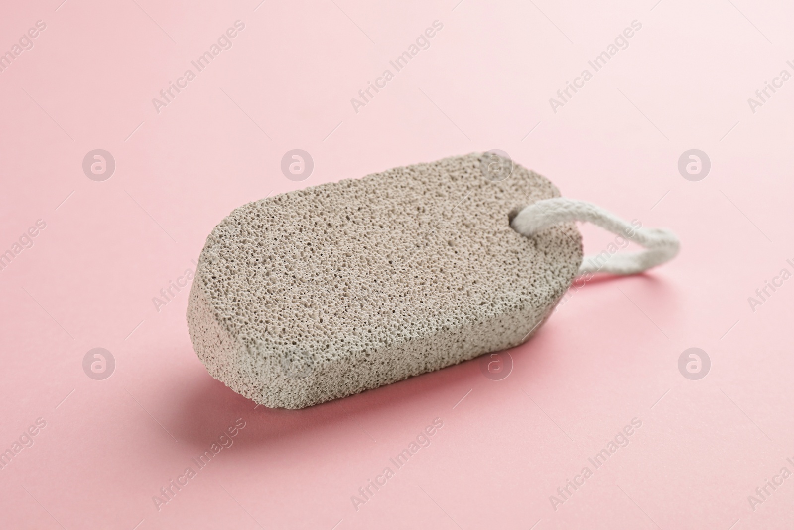 Photo of Pumice stone on pink background. Pedicure tool