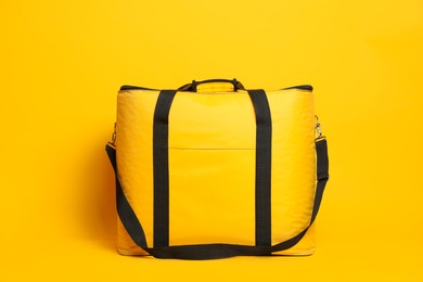 Photo of Modern large thermo bag on yellow background