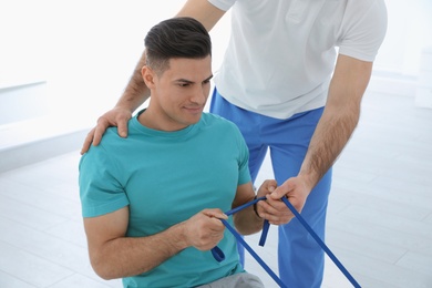 Photo of Professional physiotherapist working with male patient in rehabilitation center