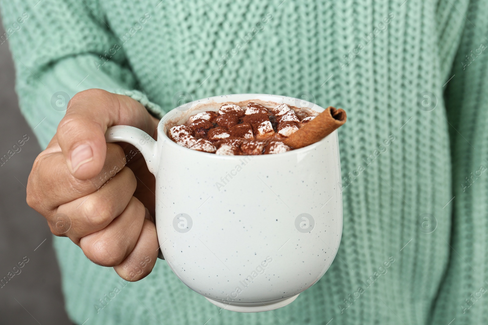 Photo of Woman holding cup of delicious hot cocoa drink with marshmallows, closeup