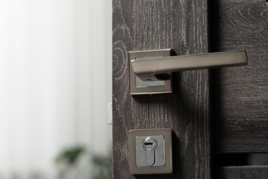Open wooden door with metal handle, closeup
