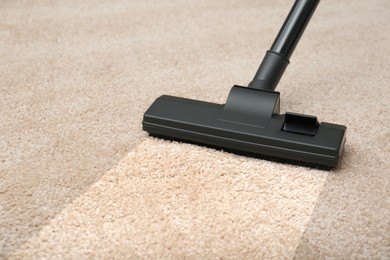 Image of Vacuuming dirty beige carpet. Clean area after using device, closeup