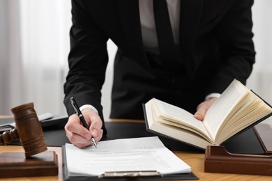 Lawyer working with documents at table indoors, closeup