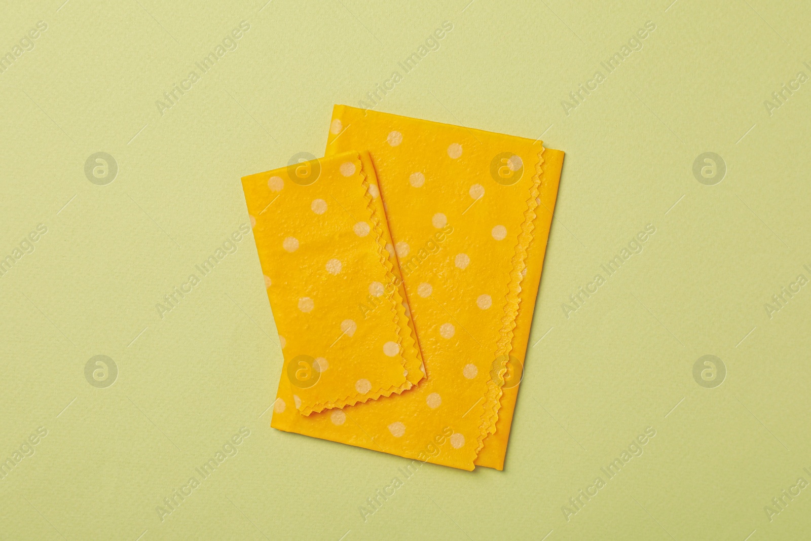 Photo of Beeswax food wraps on light green background, flat lay