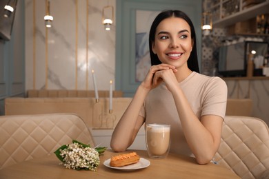 Photo of Woman with cup of coffee and dessert at cafe in morning