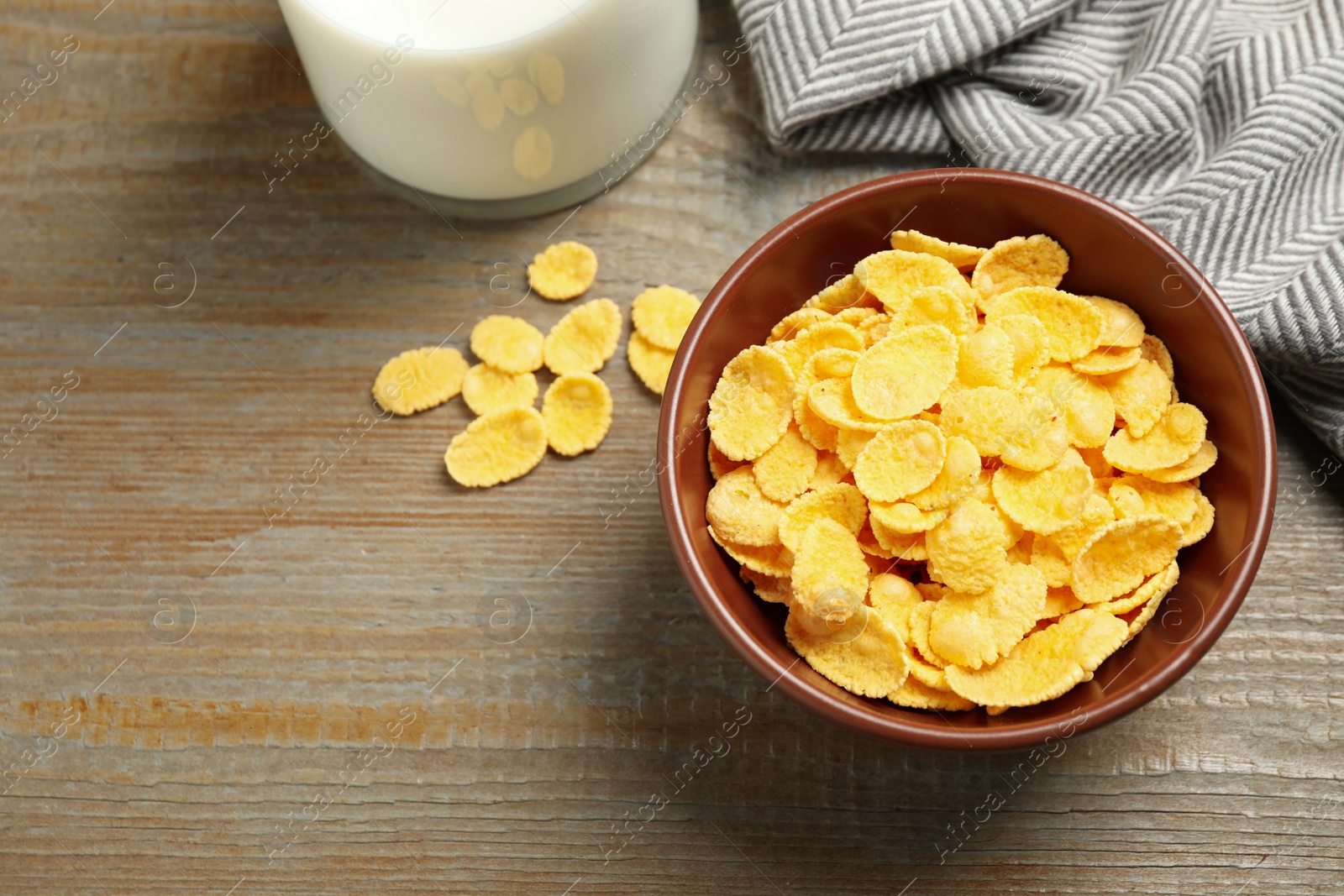 Photo of Tasty corn flakes on wooden table, above view