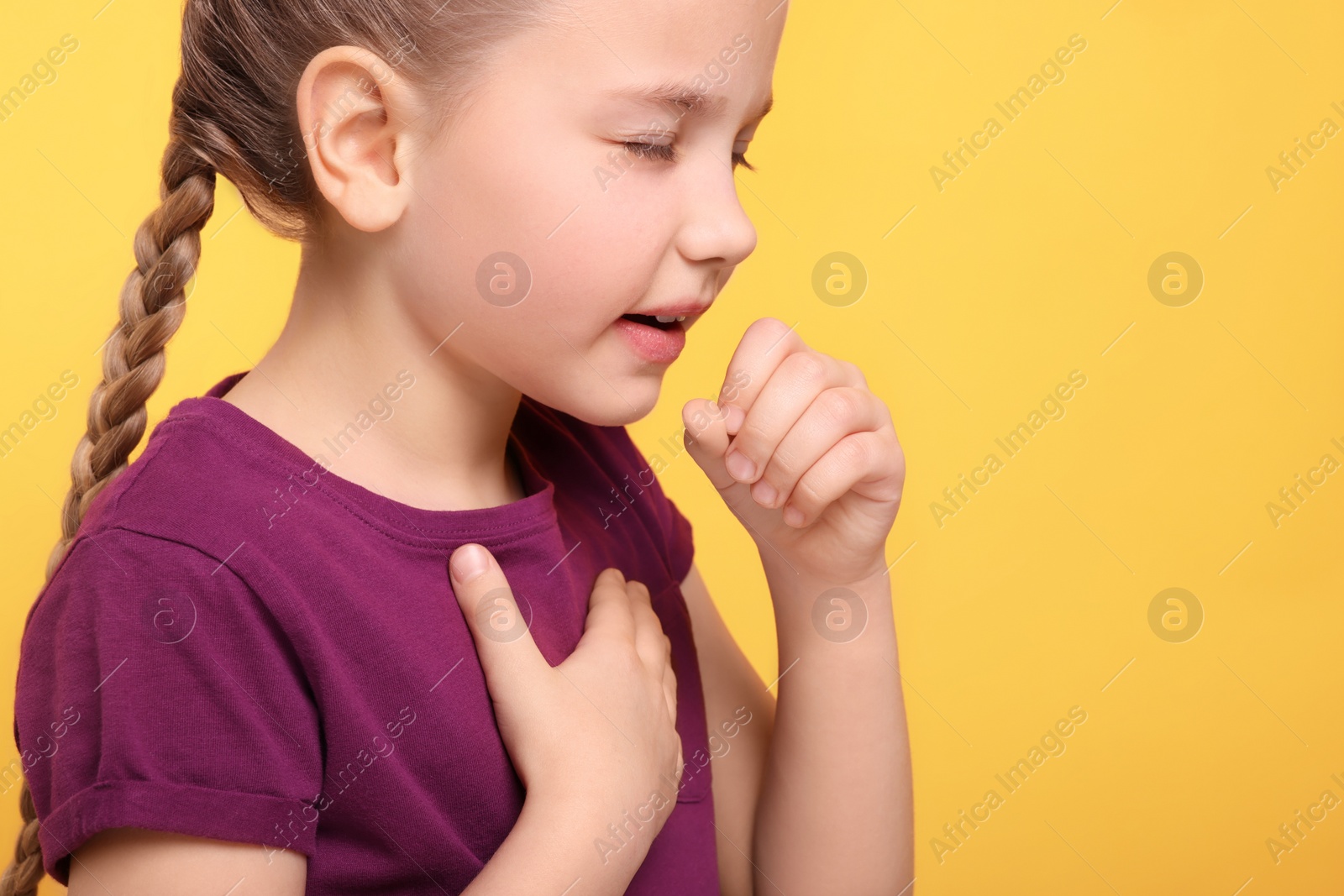 Photo of Girl coughing on orange background, closeup with space for text. Sore throat