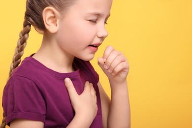 Photo of Girl coughing on orange background, closeup with space for text. Sore throat