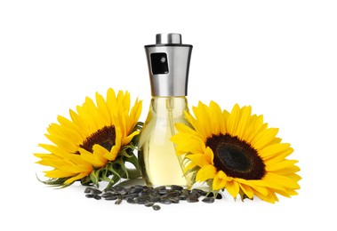 Photo of Spray bottle with cooking oil, sunflowers and seeds on white background