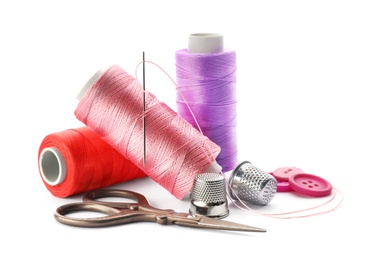 Photo of Color threads and sewing accessories on white background