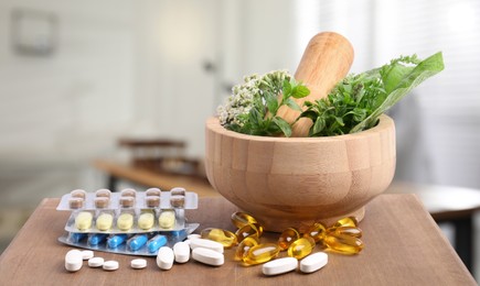 Mortar, fresh herbs and pills on wooden surface in medical office
