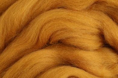 Orange felting wool as background, closeup view