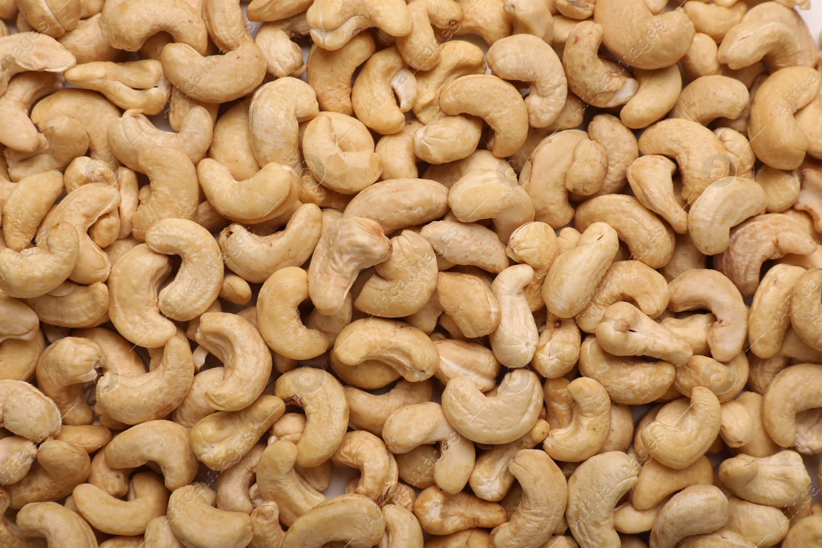 Photo of Many tasty cashew nuts as background, top view