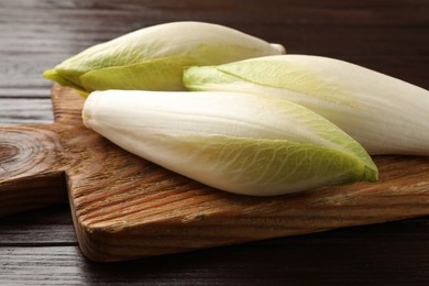 Photo of Raw ripe chicories on wooden table, closeup