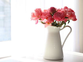 Photo of Beautiful bouquet of fragrant peonies in vase on table indoors. Space for text