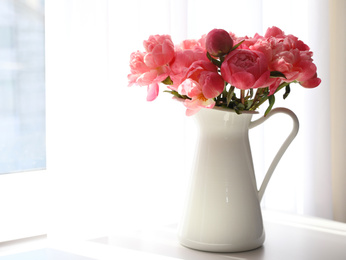 Beautiful bouquet of fragrant peonies in vase on table indoors. Space for text