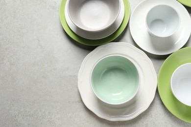 Beautiful ceramic dishware on light grey table, flat lay. Space for text