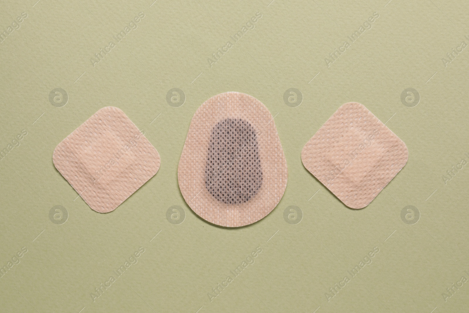 Photo of Different contraceptive patches on green background, flat lay