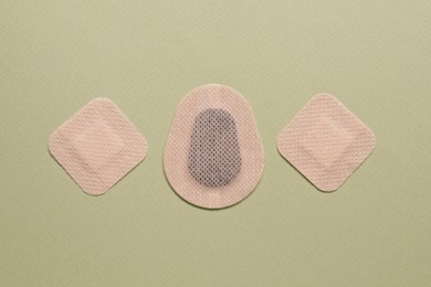 Photo of Different contraceptive patches on green background, flat lay