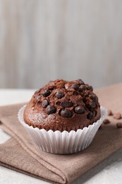 Photo of Tasty chocolate muffin on grey table, closeup. Space for text