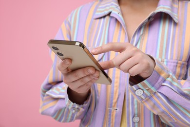 Photo of Woman sending message via smartphone on pink background, closeup