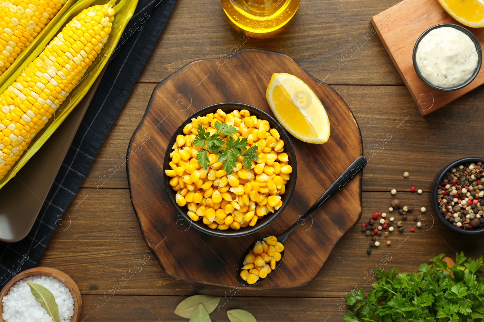 Photo of Flat lay composition with tasty boiled corn on wooden table