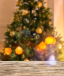 Image of Empty wooden surface and blurred view of Christmas tree in room, space for text. Interior design