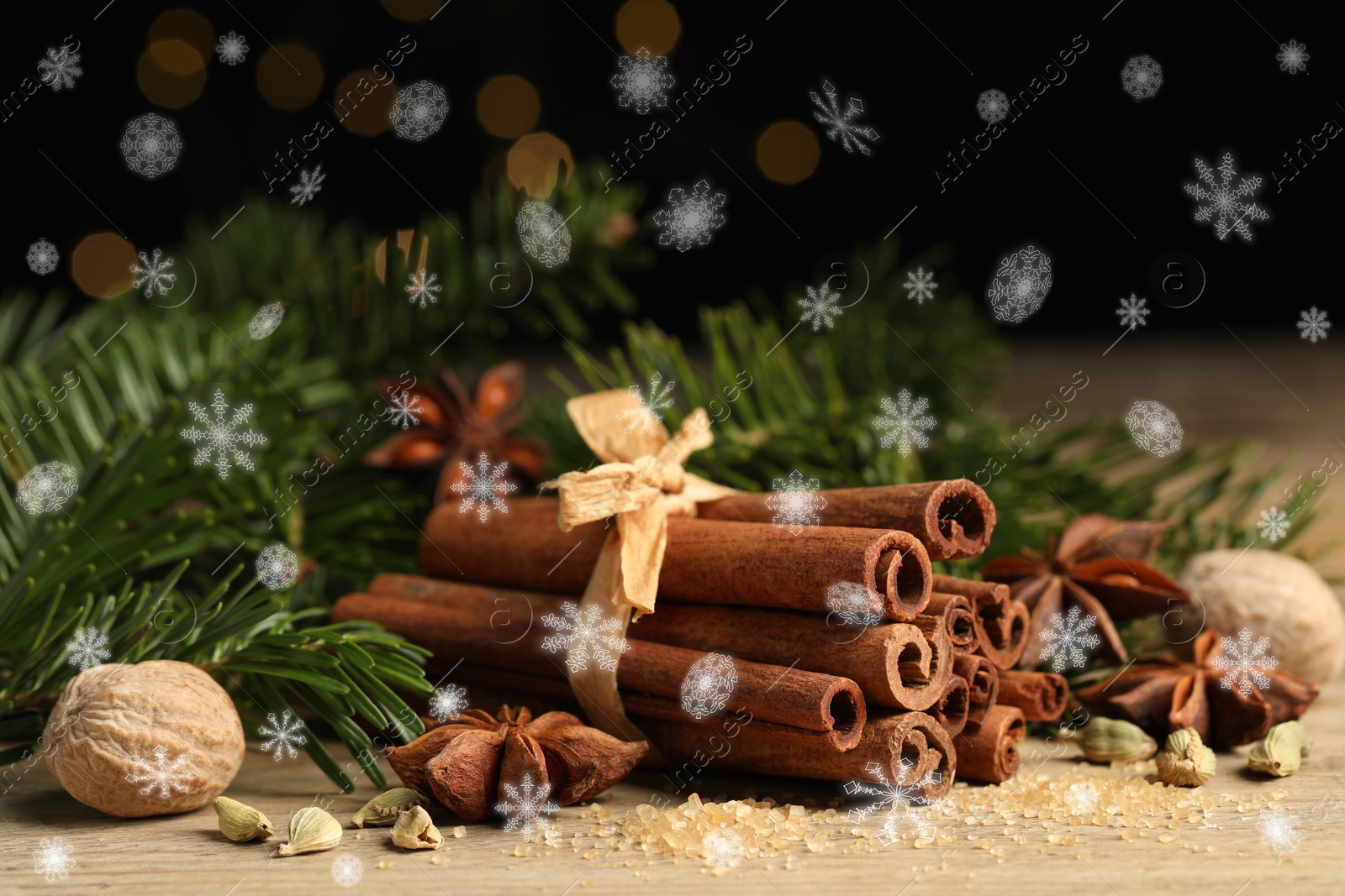 Image of Different spices and fir tree branches on wooden table, closeup. Cinnamon, anise, cardamom, nutmegs