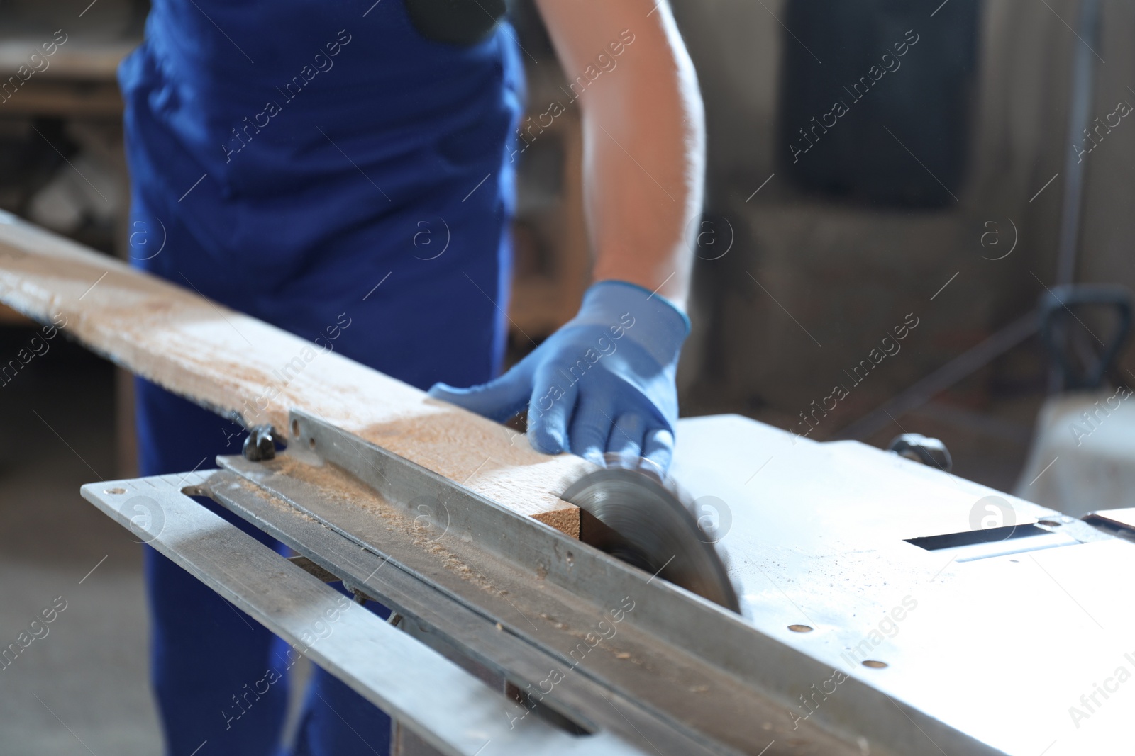 Photo of Professional carpenter working with wood in shop, closeup