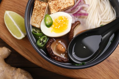 Photo of Delicious vegetarian ramen in bowl on table, top view