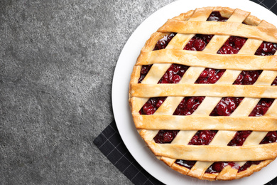 Delicious fresh cherry pie on grey table, top view. Space for text