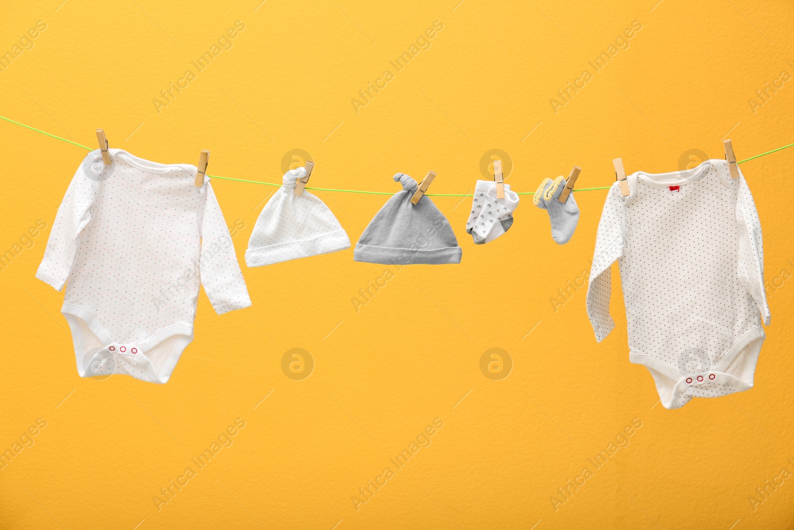 Photo of Children's clothes on laundry line against color background