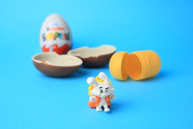 Photo of Slynchev Bryag, Bulgaria - May 25, 2023: Kinder Surprise Eggs, plastic capsule and toy bunny on light blue background